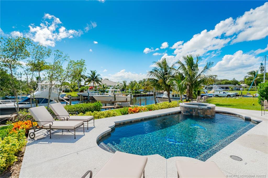 5854 Southeast Horseshoe Point Road Stuart, FL 34997 - Photo 45 of 56 a view of a swimming pool with a patio and a garden