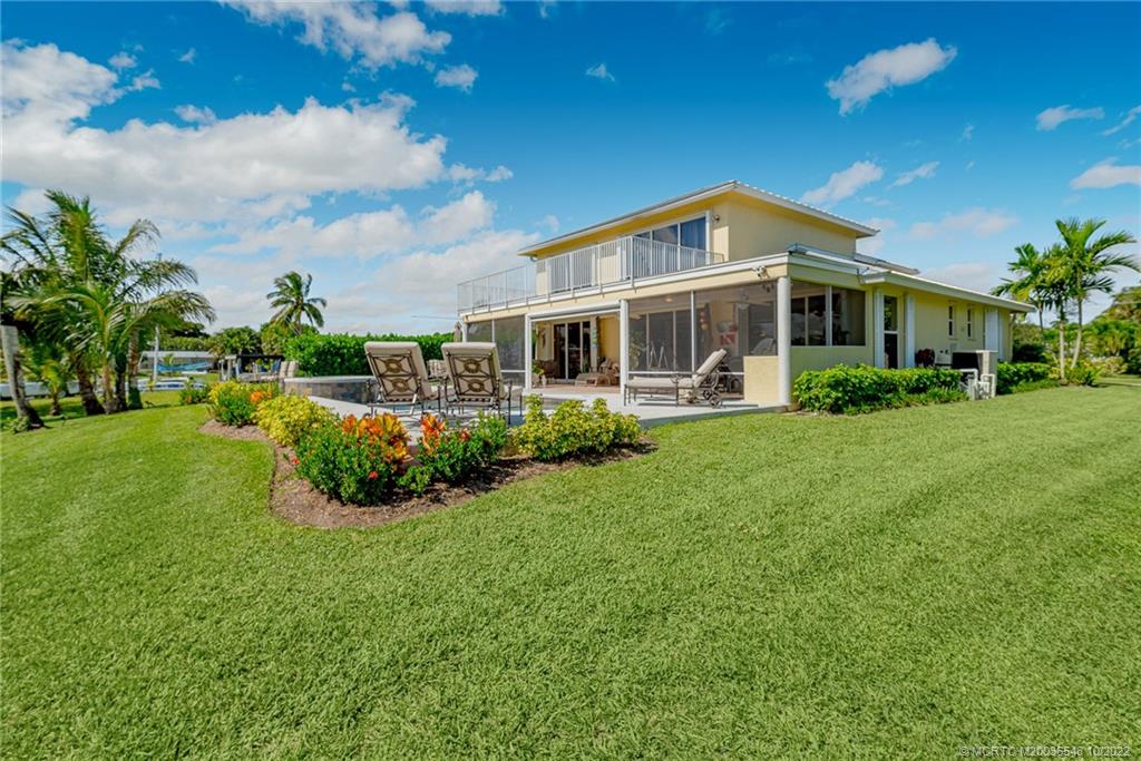 5854 Southeast Horseshoe Point Road Stuart, FL 34997 - Photo 49 of 56 a front view of a house with a yard table and chairs