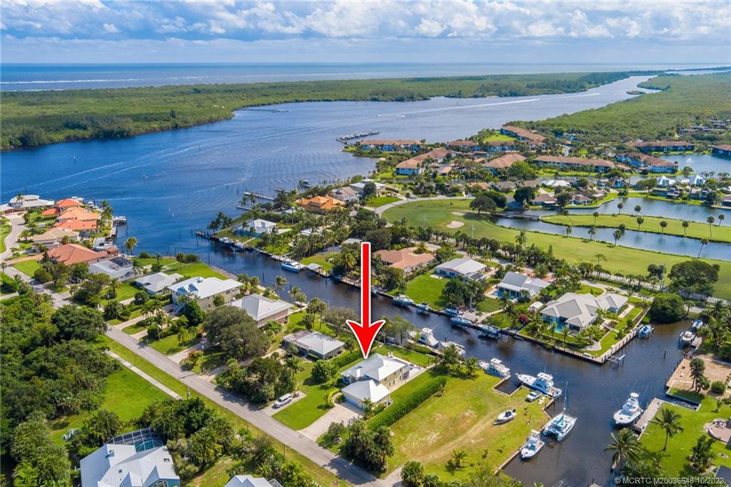 5854 Southeast Horseshoe Point Road Stuart, FL 34997 - Photo 9 of 56 an aerial view of lake residential house with swimming pool and lawn chairs