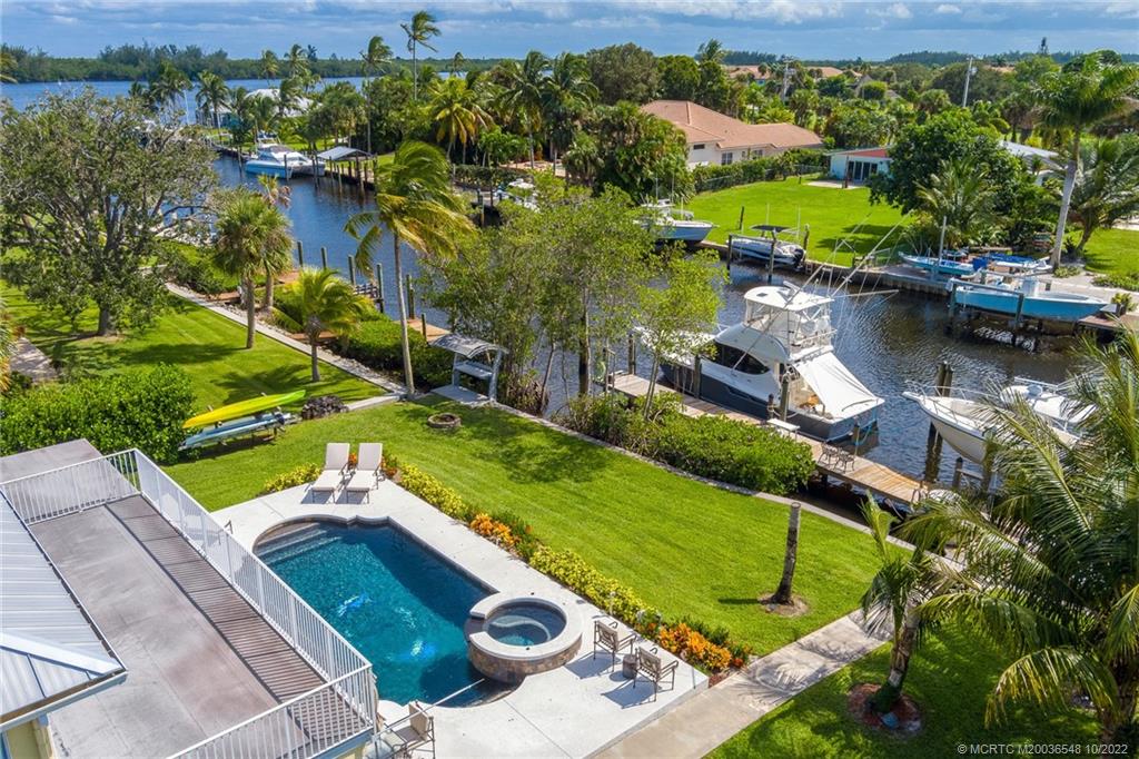 5854 Southeast Horseshoe Point Road Stuart, FL 34997 - Photo 10 of 56 an aerial view of a house with a garden and lake view