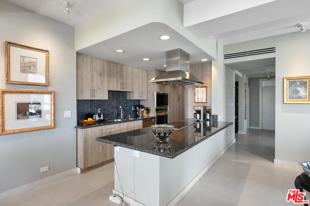 2222 Avenue Of The Stars, Unit 1404 Los Angeles, CA 90067 - Photo 5 of 12 a kitchen with stainless steel appliances granite countertop a sink and a refrigerator