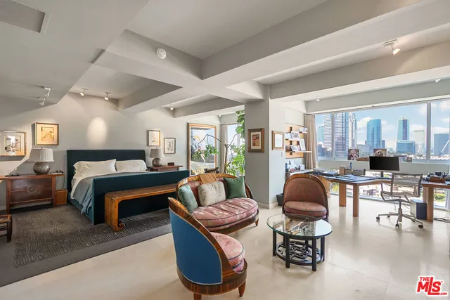 a living room with furniture a rug kitchen view and a large window