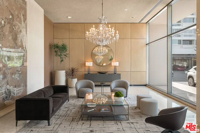 a living room with furniture a chandelier and a large mirror