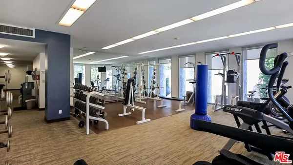 a living room with furniture gym equipment and a large window