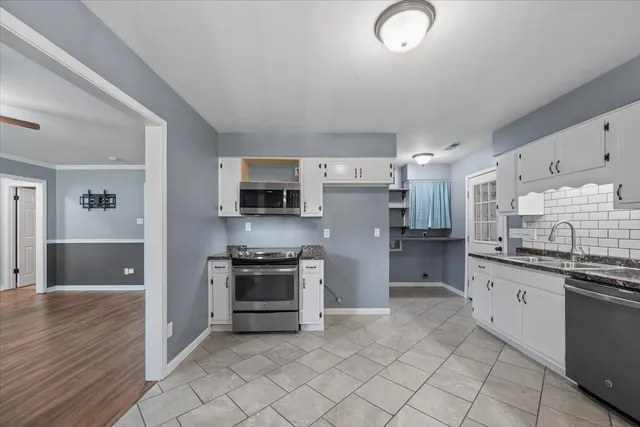a kitchen with stainless steel appliances a stove sink and microwave