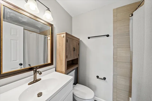 a bathroom with a sink a toilet and shower
