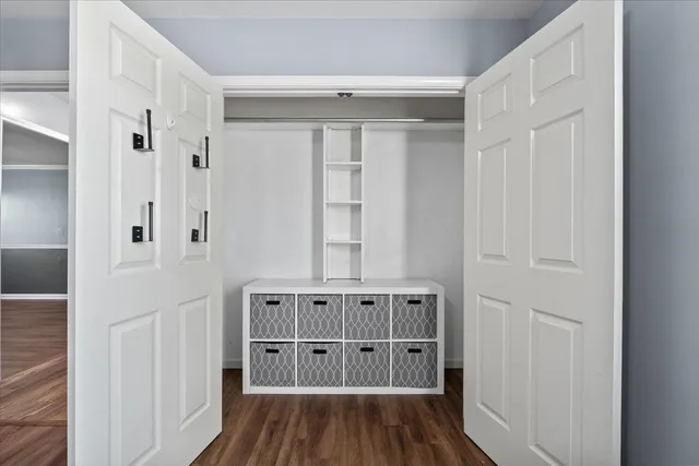 a view of walk in closet with wooden floor