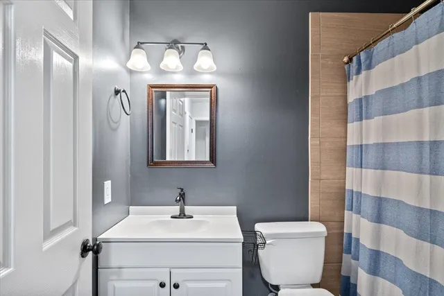 a bathroom with a sink toilet and mirror