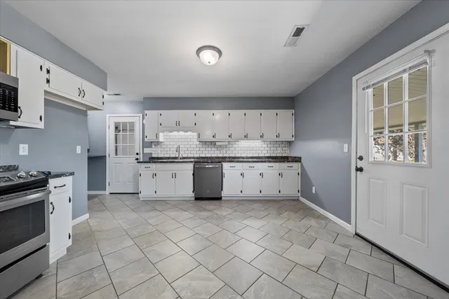 a kitchen with a stove a sink and a refrigerator