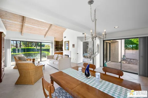 a dining room with wooden floor and a chandelier