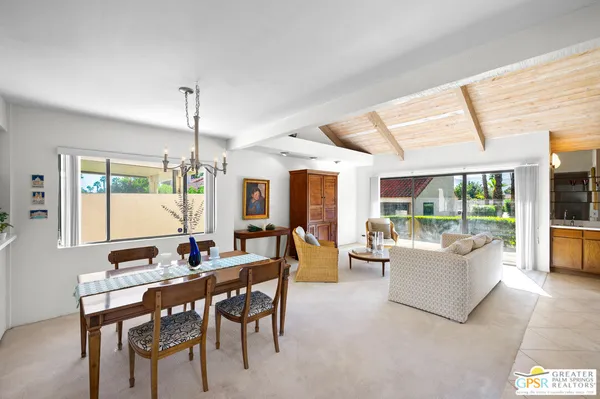 a view of a dining room with furniture large windows and wooden floor