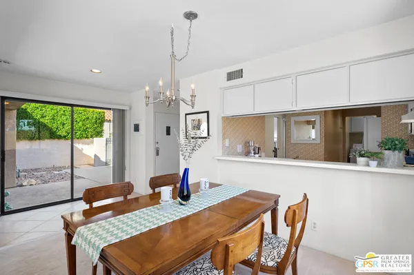 a dining room with furniture a chandelier and window