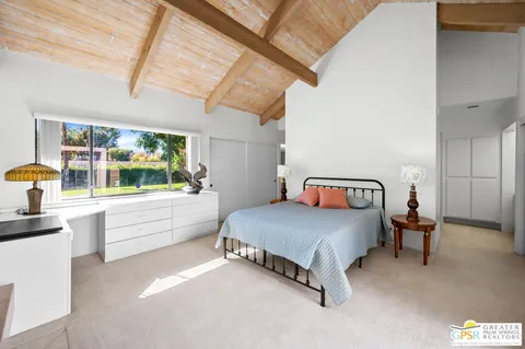 a bedroom with a bed and a large window