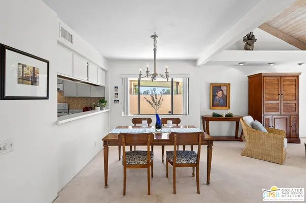 a dining room with furniture a rug and a chandelier