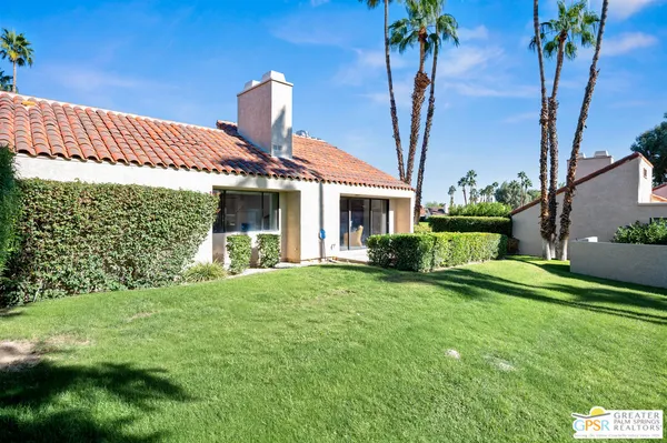 a front view of a house with a garden and yard