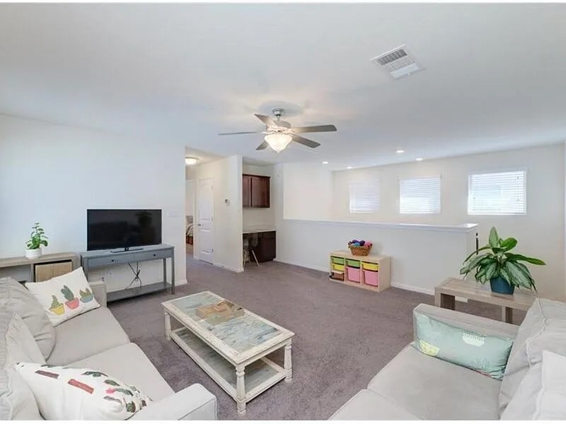 167 Iron Rail Road Dripping Springs, TX 78620 - Photo 6 of 17 Carpeted living area featuring a ceiling fan