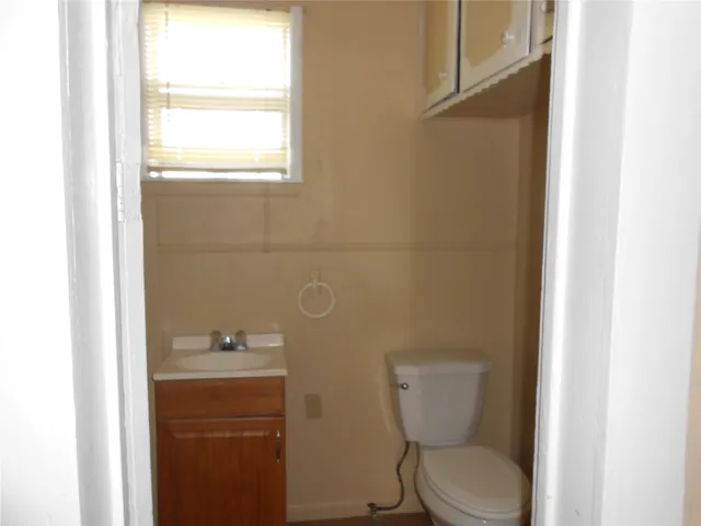 a bathroom with a toilet sink and mirror