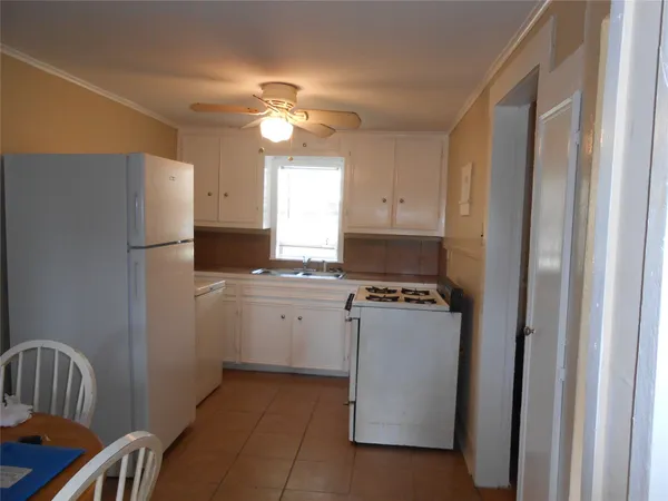 a kitchen with a refrigerator and a stove top oven