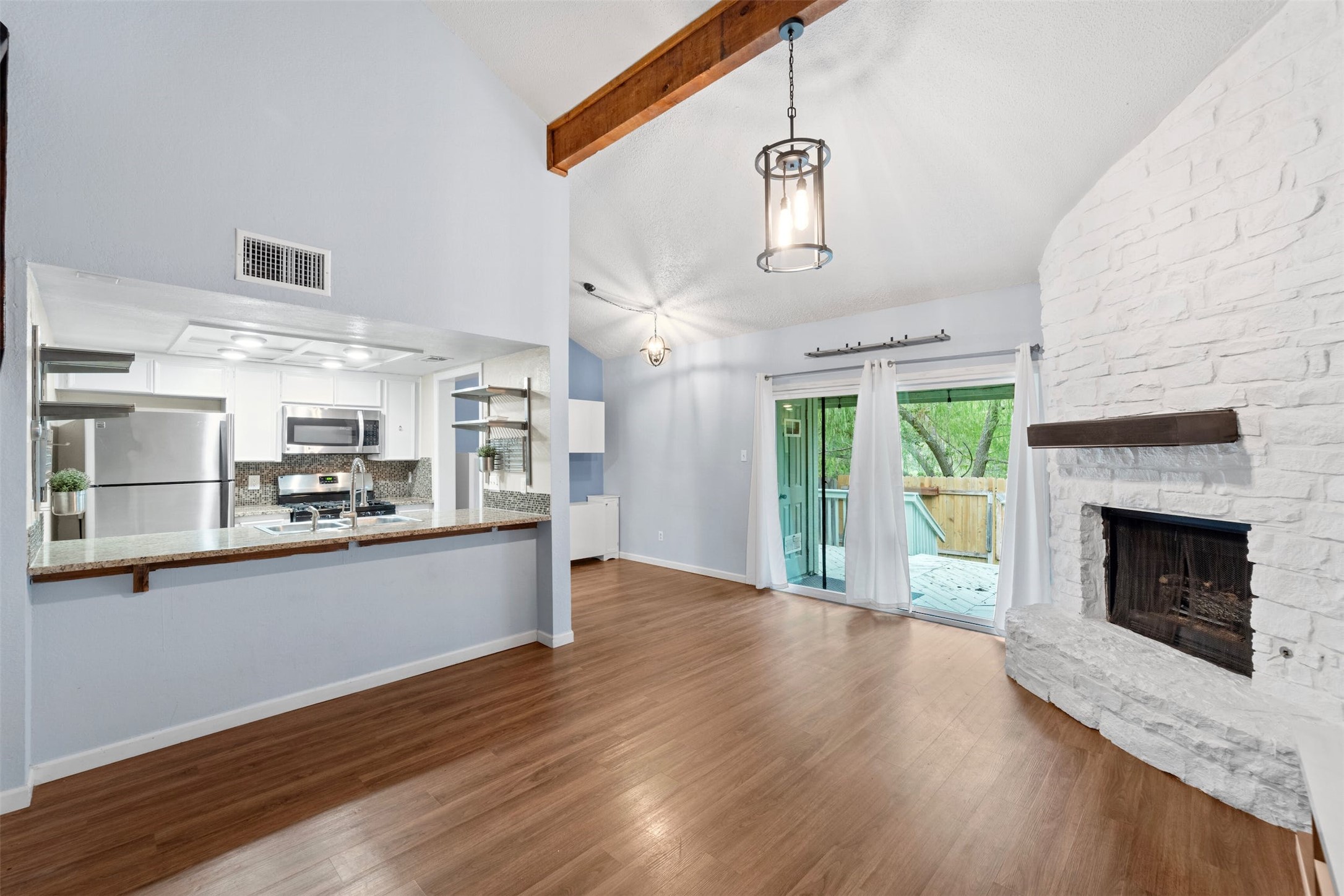 a view of a kitchen with furniture a fireplace and wooden floor