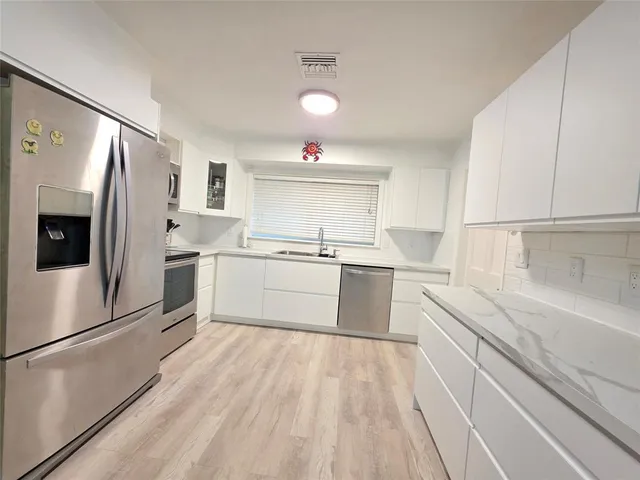 a bedroom with a bed a dresser and next to a window