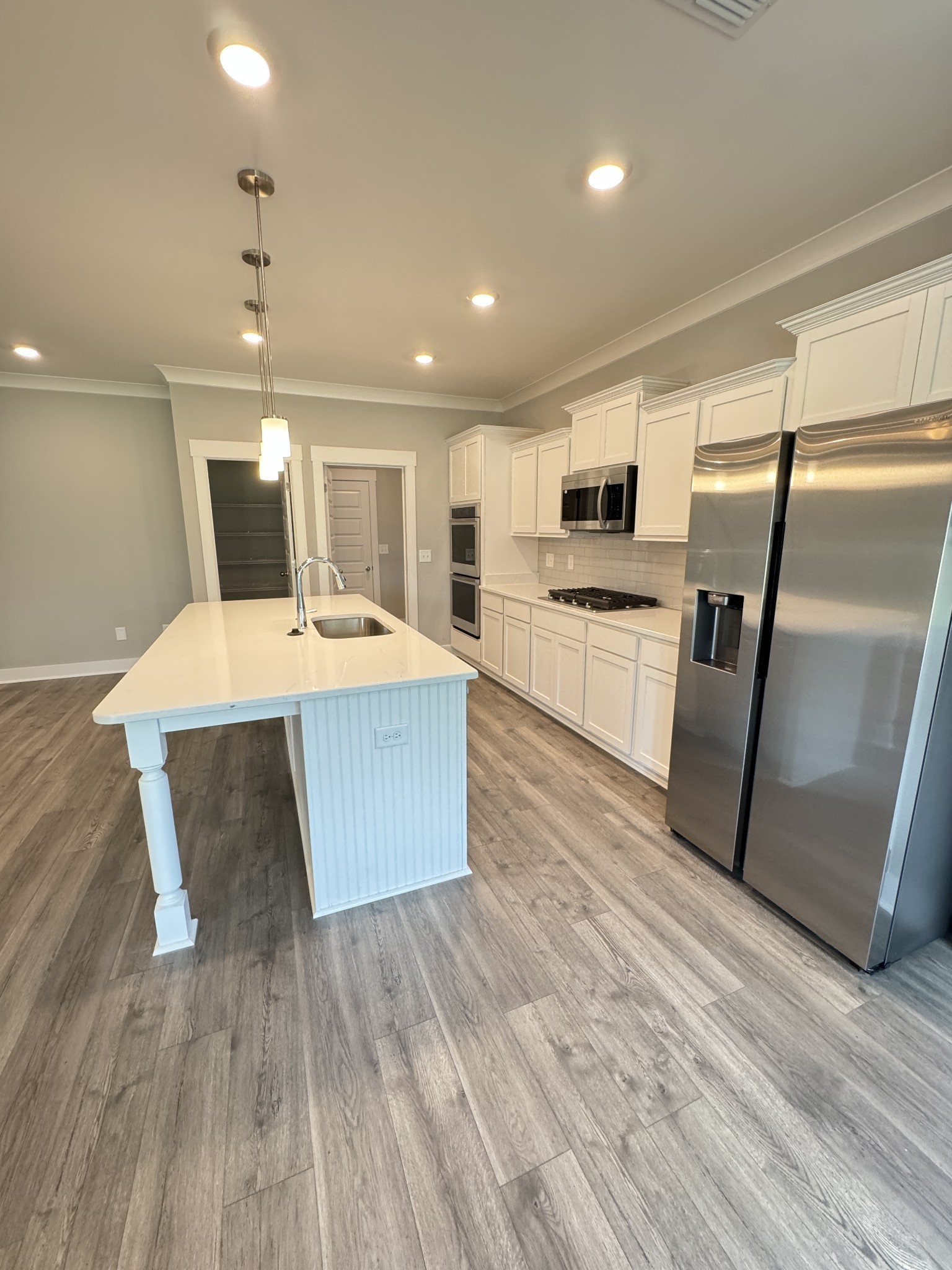 5482 Rooker Road Smyrna, TN 37167 - Photo 9 of 30 a large kitchen with kitchen island a stove a sink dishwasher a refrigerator and wooden floor