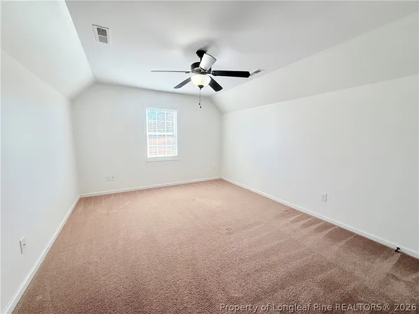 a view of an empty room with a ceiling fan