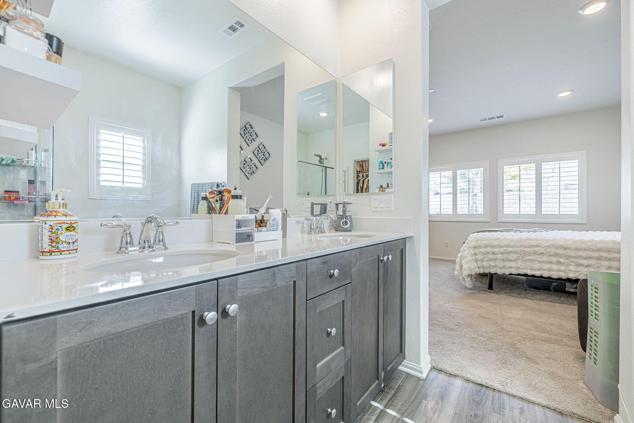 44302 Marbella Street Lancaster, CA 93536 - Photo 8 of 38 a en suite bathroom with a double vanity sink a mirror a bathtub and window