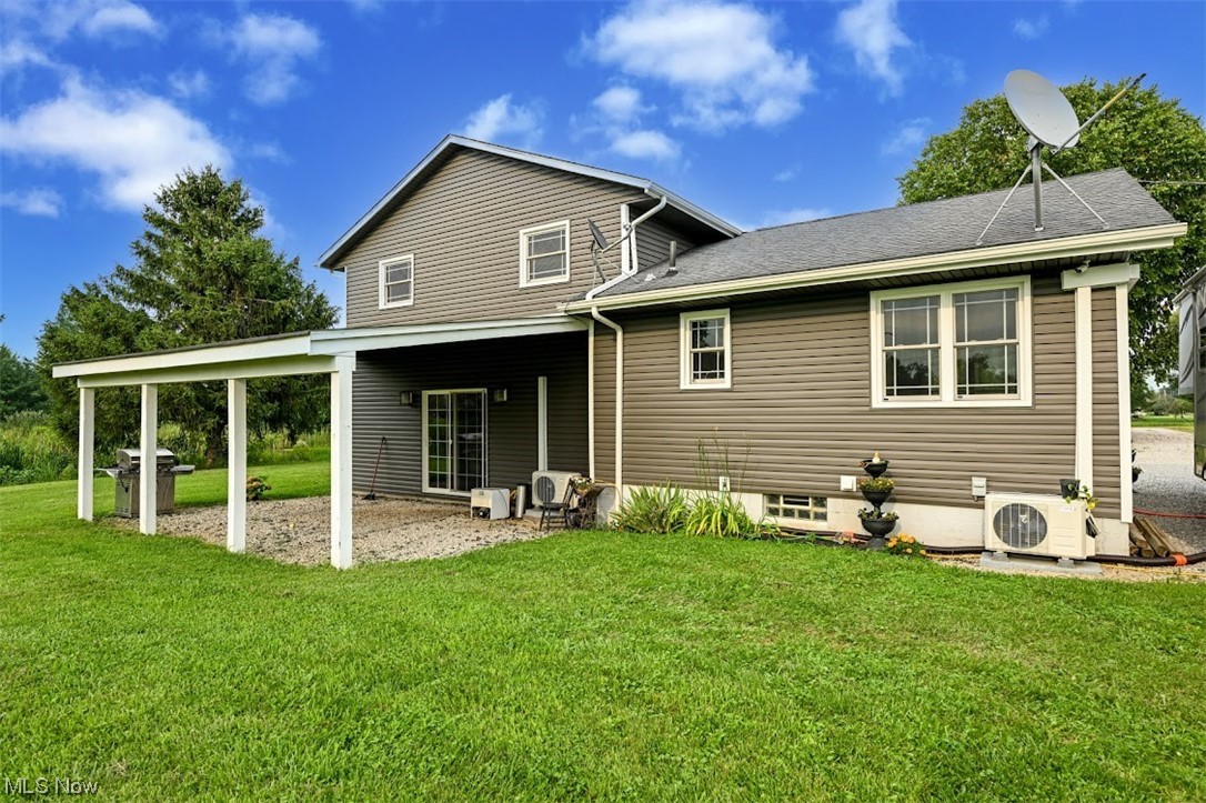 3368 Erhart Road Litchfield, OH 44253 - Photo 29 of 35 Back of house featuring central AC and a lawn