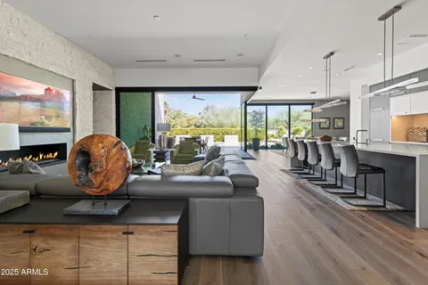 a living room with furniture a flat screen tv and a floor to ceiling window