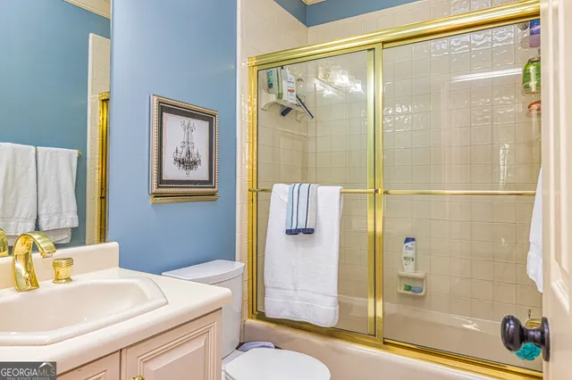 a kitchen that has a lot of white cabinets and stainless steel appliances