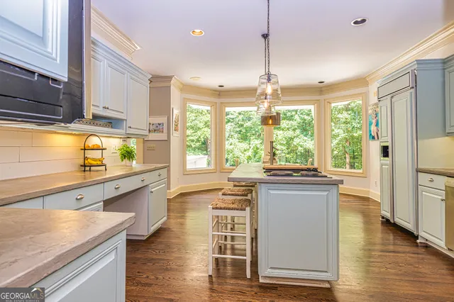 a view of a hallway with wooden floor and a bathroom