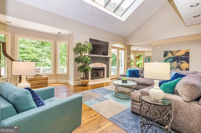 a bedroom with a bed couch and a large window with wooden floor