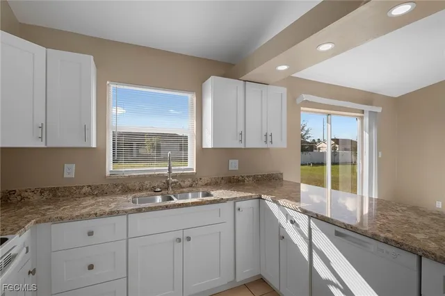 a kitchen with granite countertop a sink white cabinets and a granite counter tops