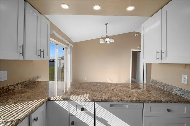 a kitchen with kitchen island granite countertop a sink and a stove