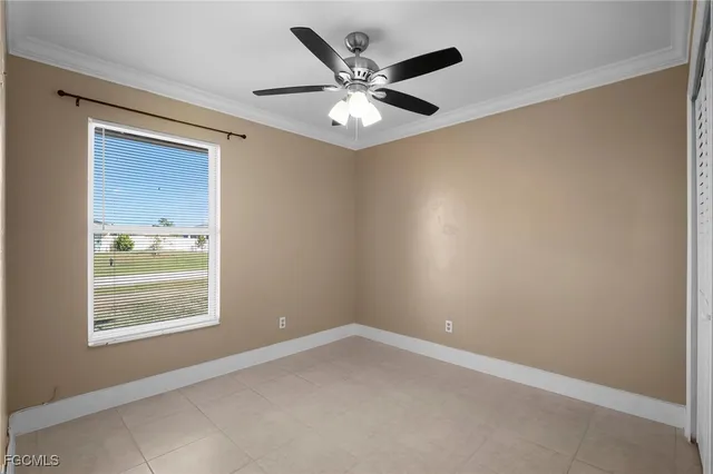 an empty room with a window and a ceiling fan