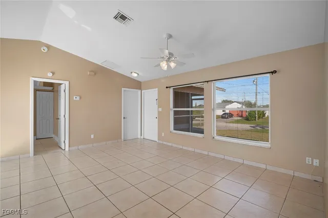 a view of an empty room with a window and cabinet