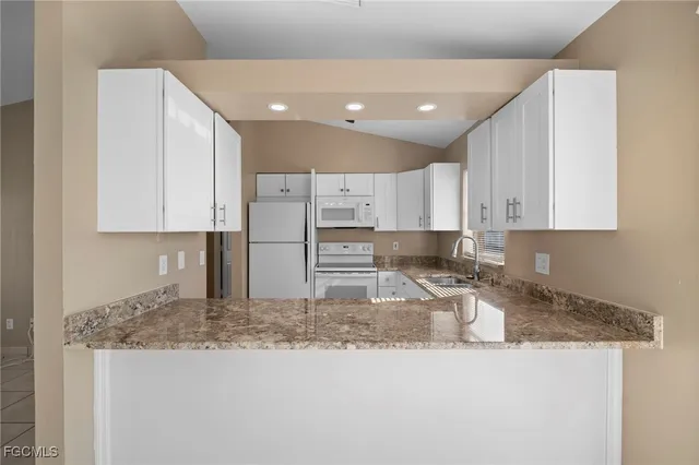 a kitchen with granite countertop white cabinets and a granite counter tops