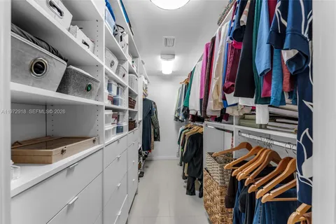 a view of walk in closet with clothes and shoes