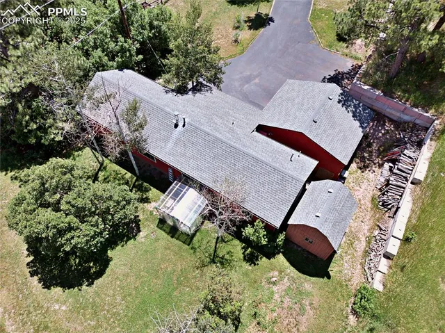 an aerial view of a house with a yard and large trees