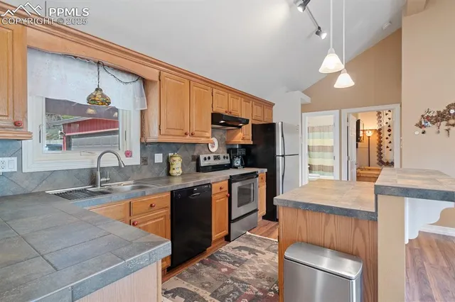 a kitchen with stainless steel appliances granite countertop a sink stove and refrigerator
