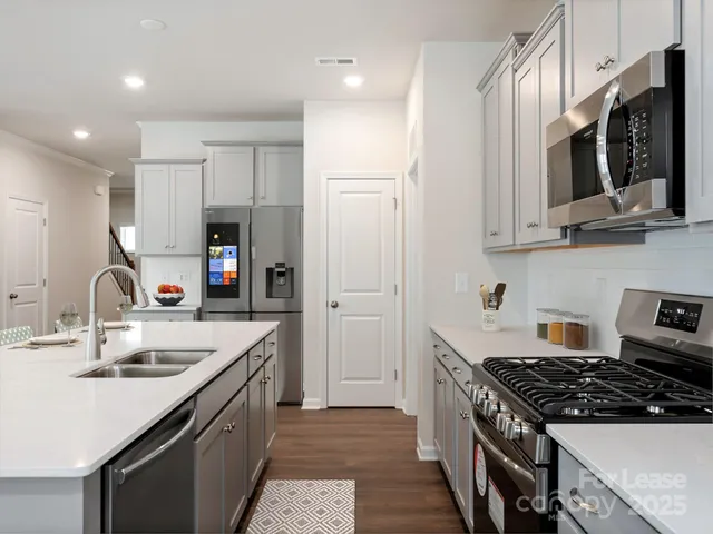 a kitchen with stainless steel appliances granite countertop a sink stove and refrigerator