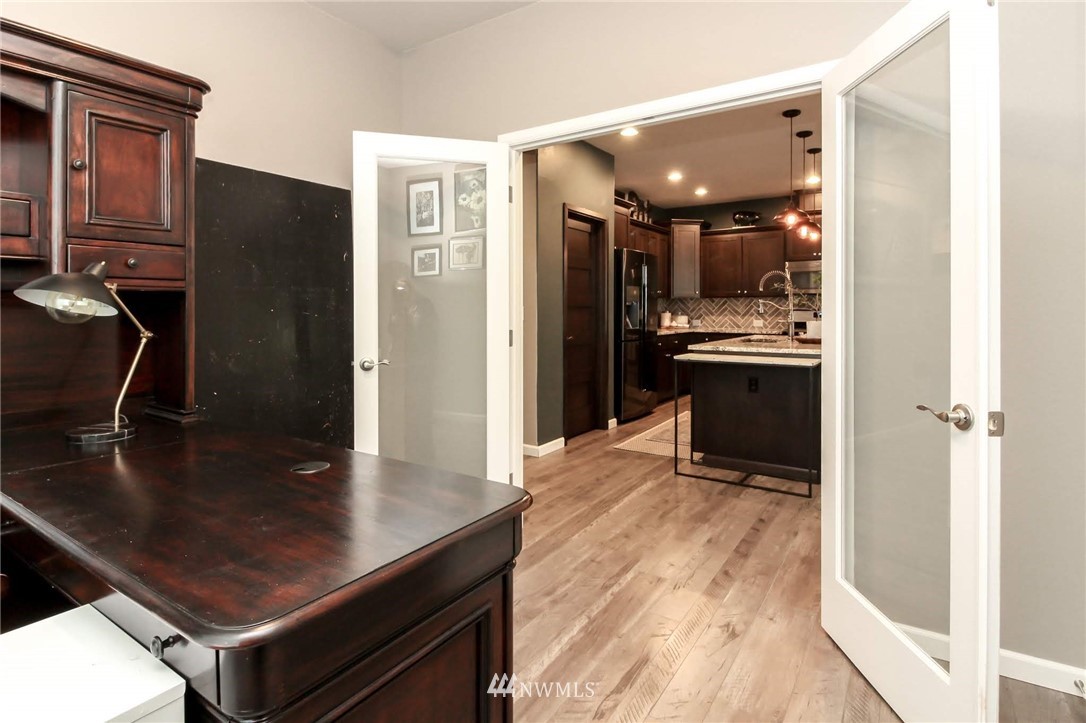 4716 Rosa Court Lacey, WA 98503 - Photo 22 of 25 a kitchen with stainless steel appliances granite countertop a refrigerator a stove and a sink with wooden floors