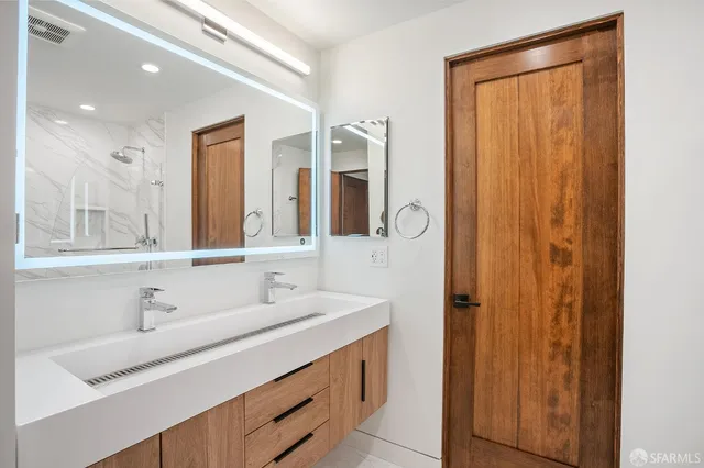 a bathroom with a double vanity sink and a mirror
