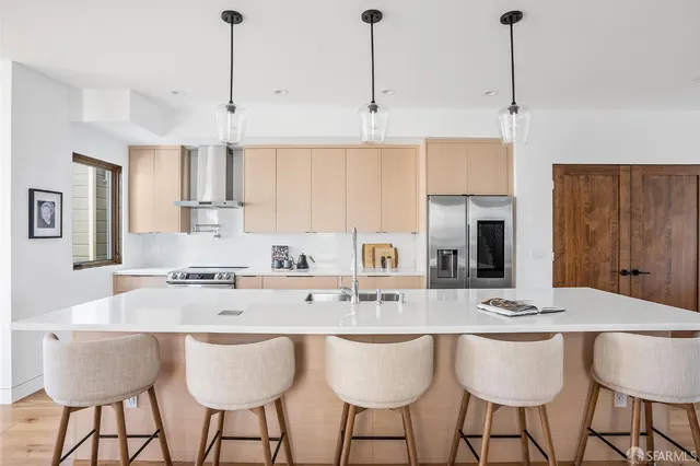 a kitchen with stainless steel appliances granite countertop a sink a stove a dining table and chairs