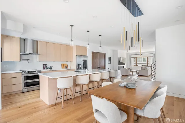 a large kitchen with kitchen island a dining table chairs and a stove