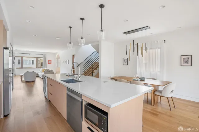 a open kitchen with stainless steel appliances granite countertop a stove and chairs