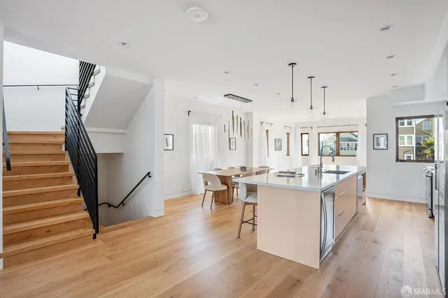 a view of a kitchen with furniture and wooden floor