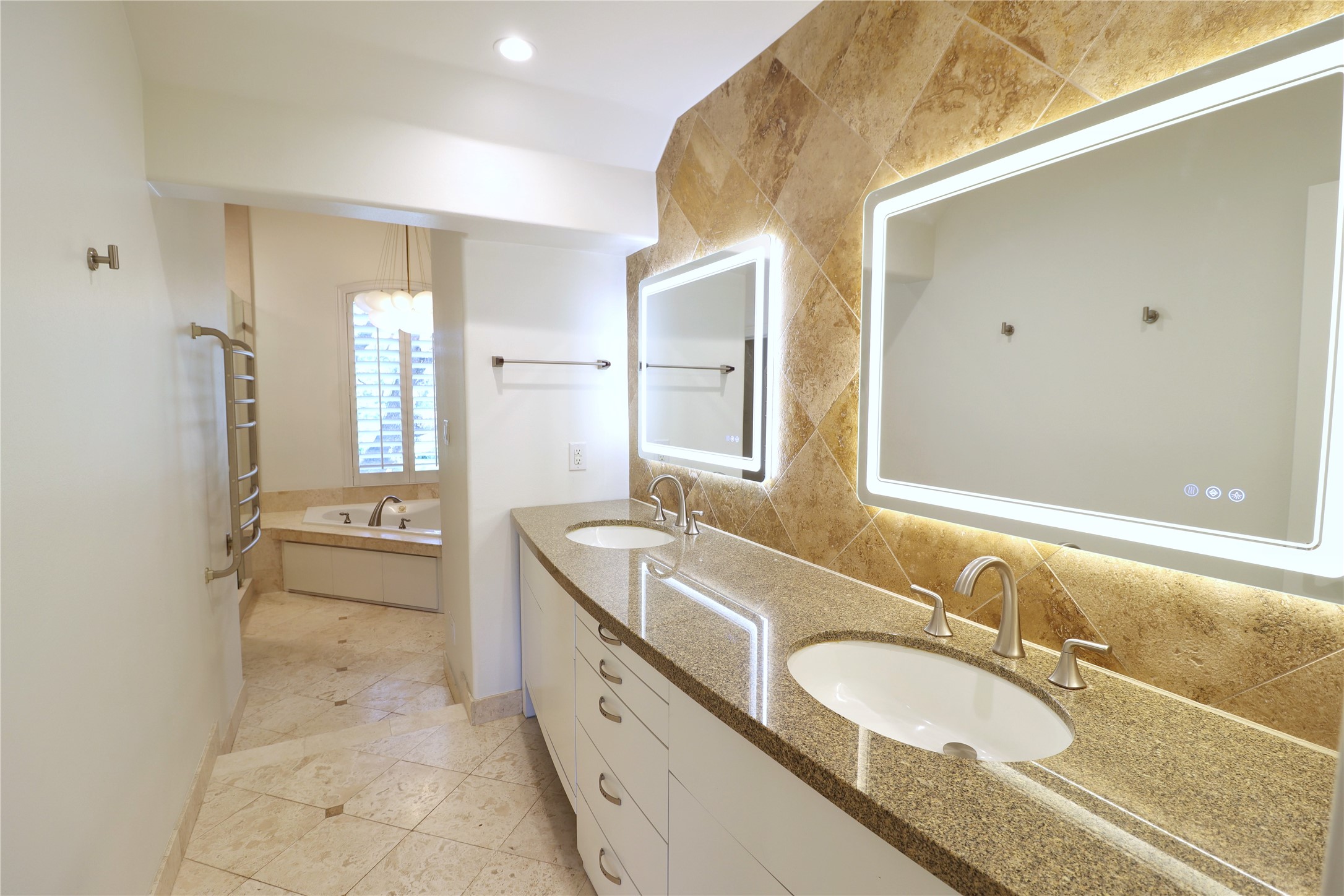 2003 Chilton Road Houston, TX 77019 - Photo 11 of 17 Landlord has recently refreshed the spacious primary bath. Notice the dual vanities with recent illuminated mirrors! This primary bath has all you need: abundant countertop space and cabinet storage, a separate soaking tub and and a good sized walk-in shower.