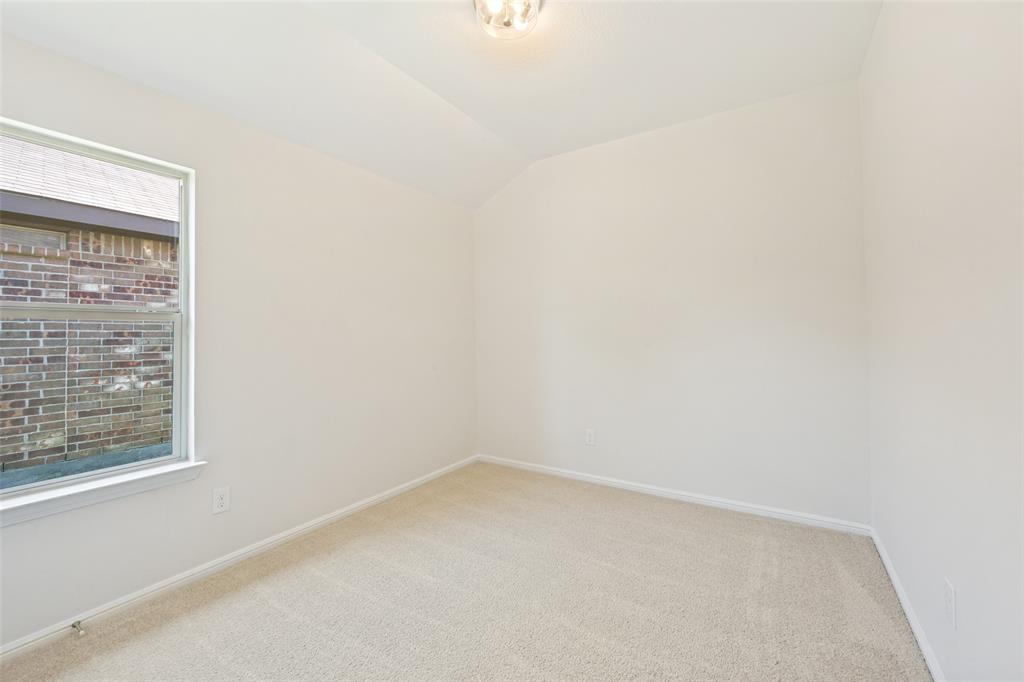 857 Watson Way Crowley, TX 76036 - Photo 14 of 25 Neutral-toned room featuring a single window with brick exterior visibility, light beige carpeting, white walls, and a contemporary ceiling light fixture