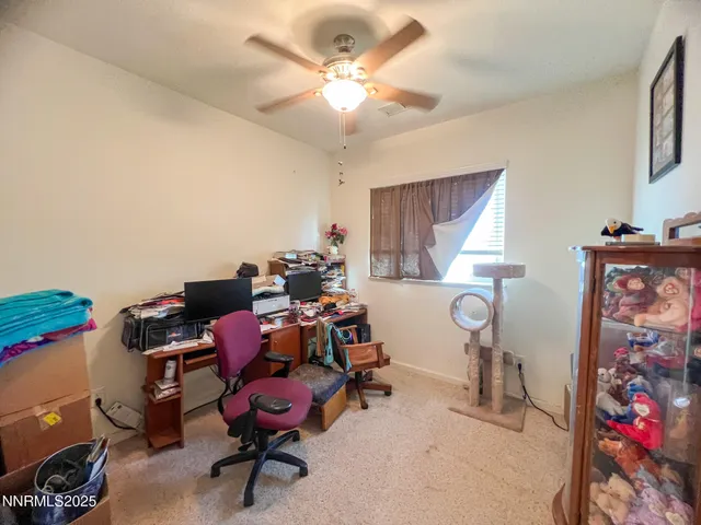 a view of a workspace with furniture and a window